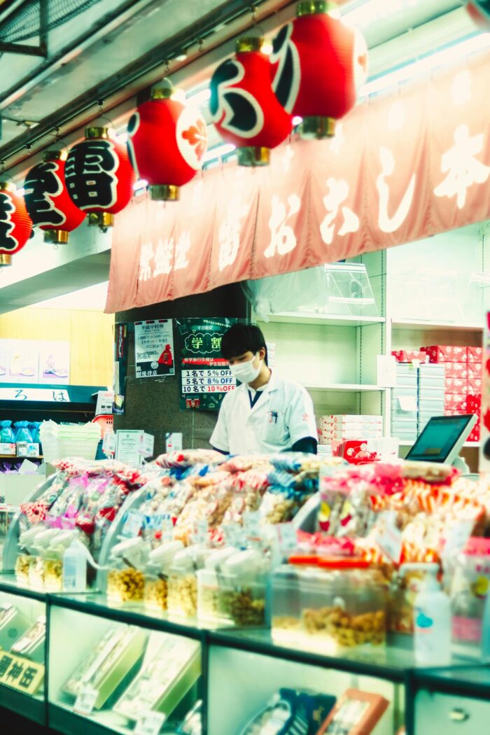 A Japanese store with a variety of colorful candies and vibrant red lanterns.