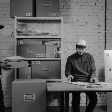 Courier workers organizing packages at an office, ensuring efficient logistics and delivery services.